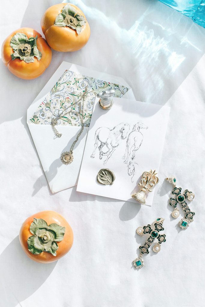 Minimal flat lay featuring artisan jewelry, earrings, and gift-ready stationery