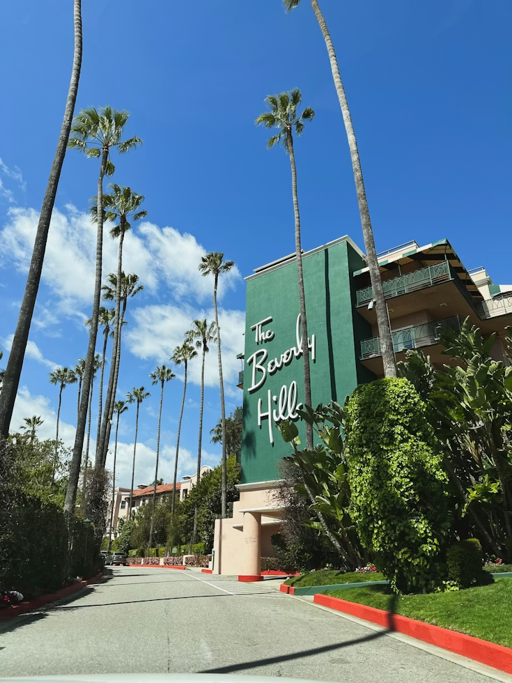 Entrance of The Beverly Hills Hotel surrounded by palm trees