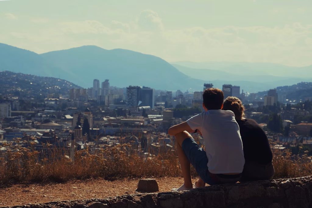 Couple overlooking Sarajevo skyline and surrounding mountains at sunset