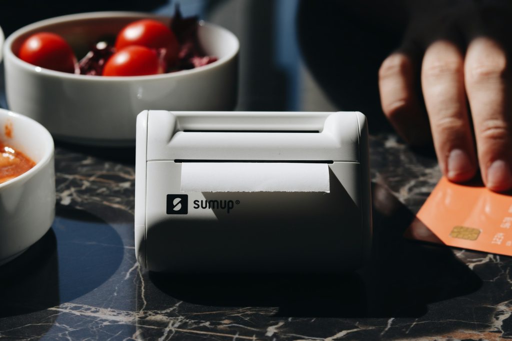 Card payment terminal printing receipt in café setting