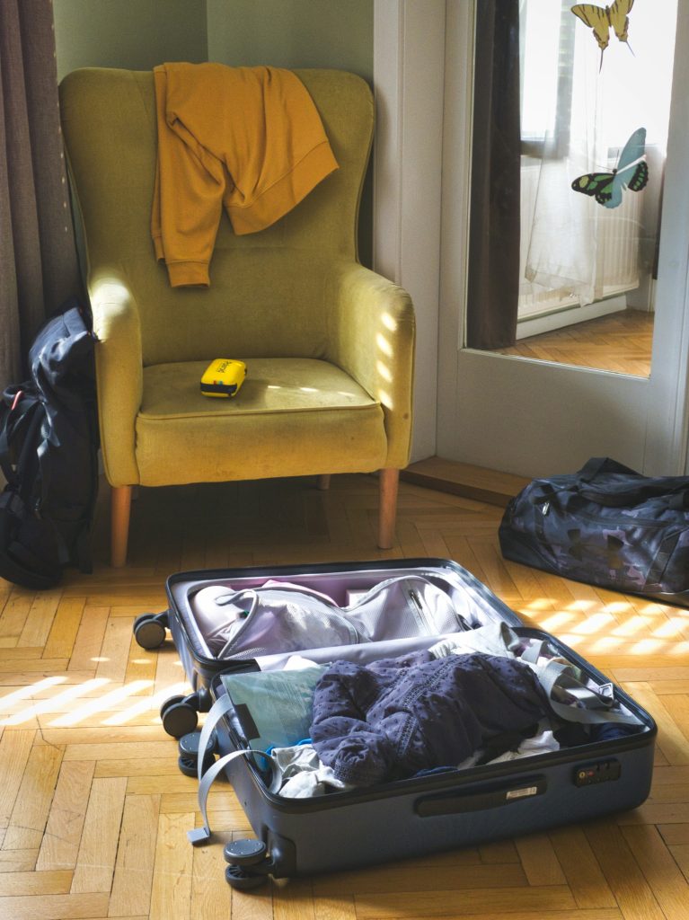 Open suitcase with clothes and travel items ready for packing