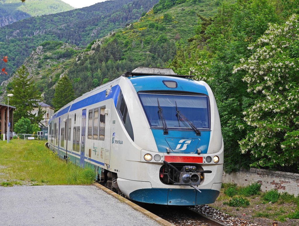 Regional train traveling through a green mountainous landscape