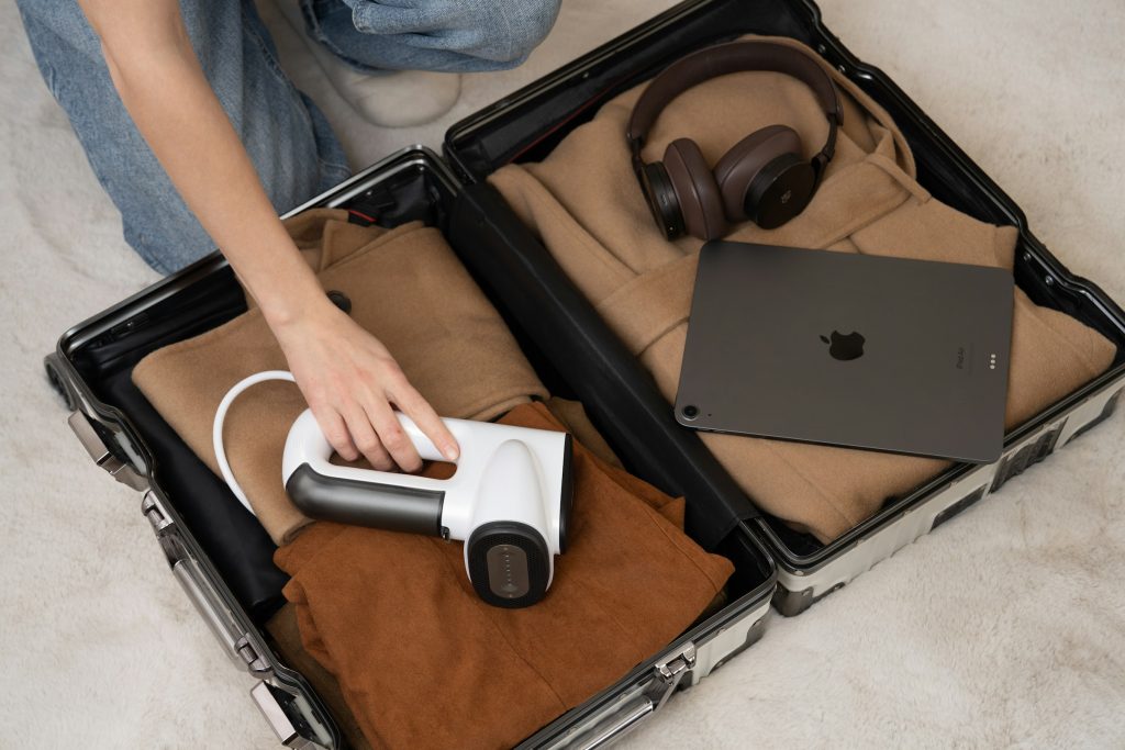 Packing clothes and electronics into suitcase for a trip
